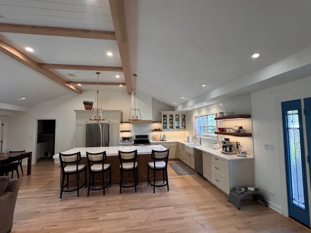 Oak hardwood floor in an open kitchen with a beamed ceiling